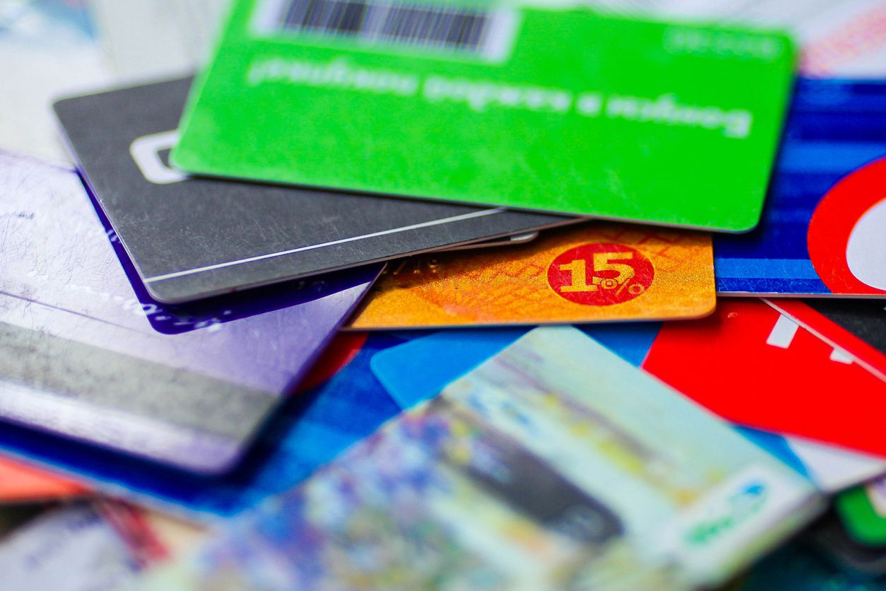 A close-up image of a pile of different colored store gift cards.