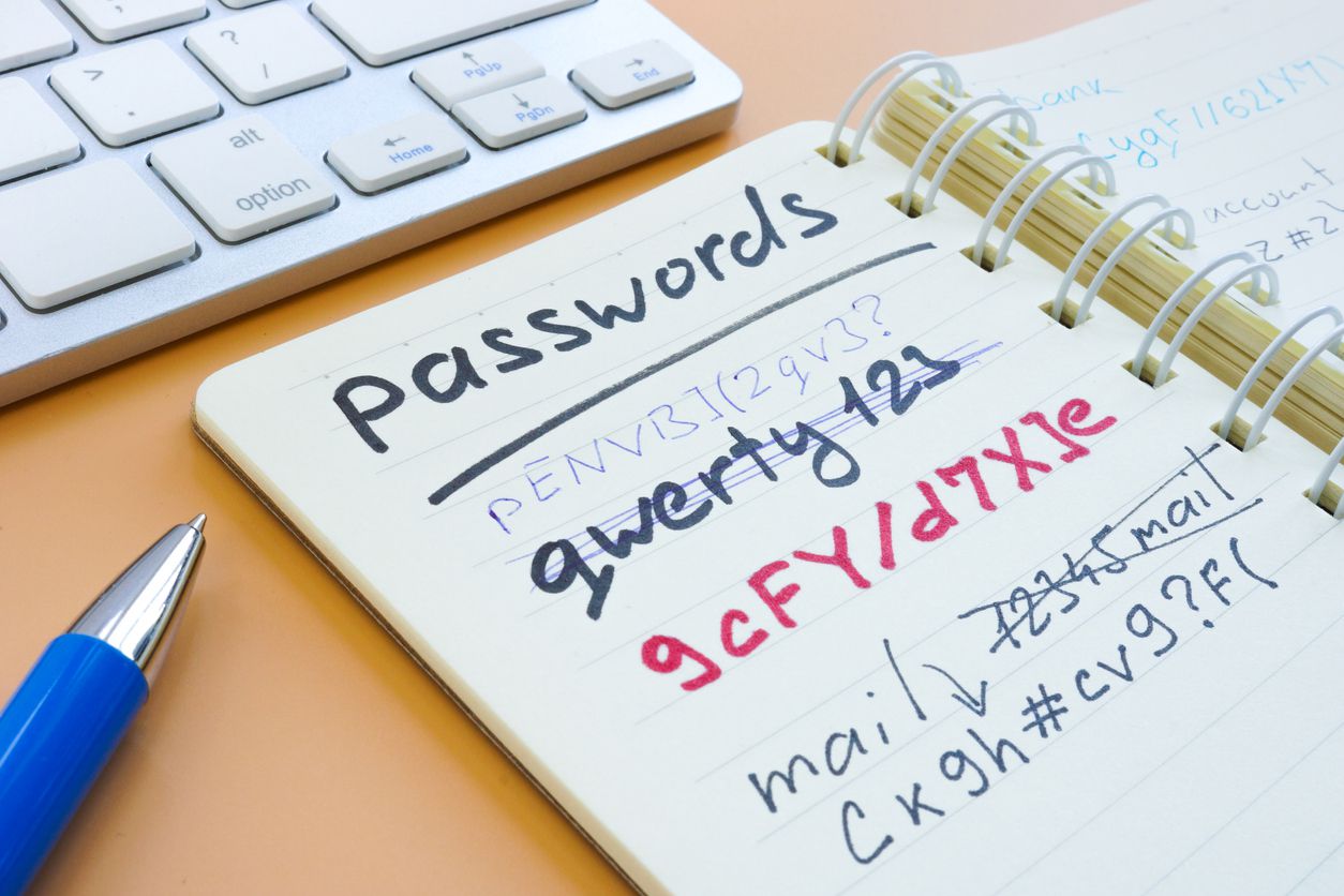 An image of a notepad with various passwords written in pen on it.