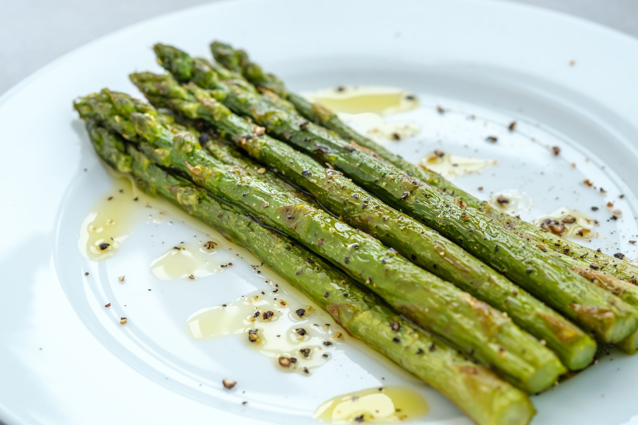 Bunch of cooked asparagus on the white plate