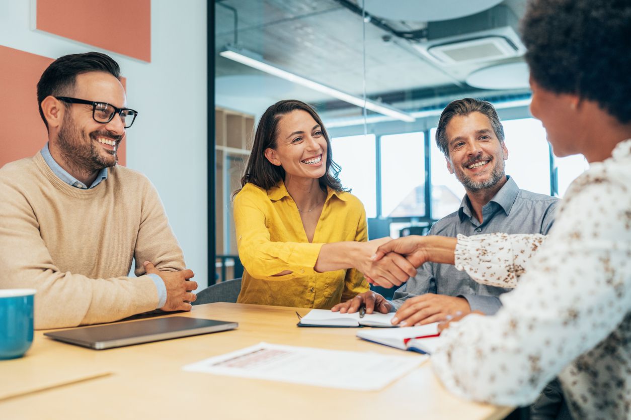 A job applicant shaking the hands of an interviewer.