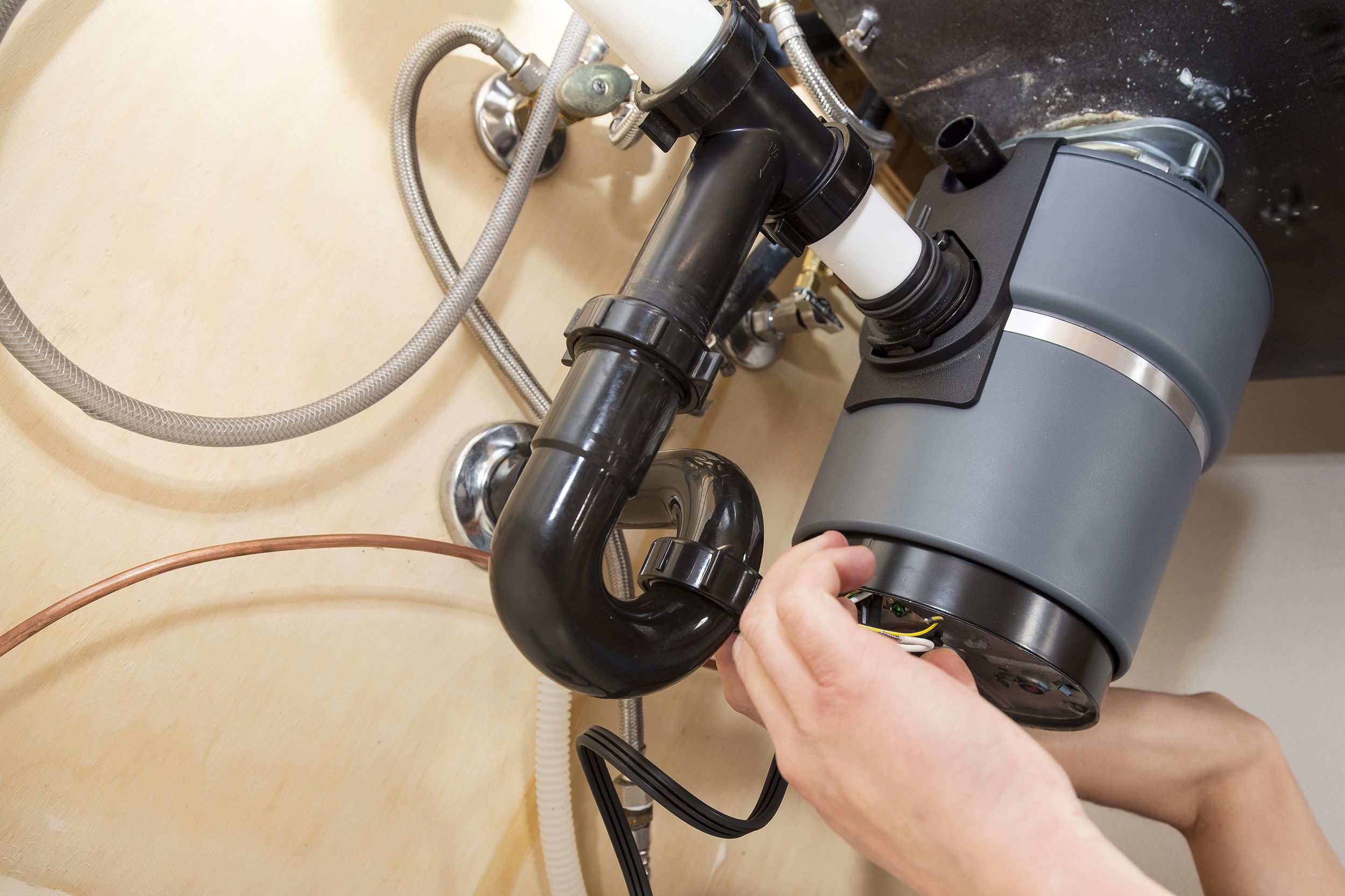 man installing garbage disposal