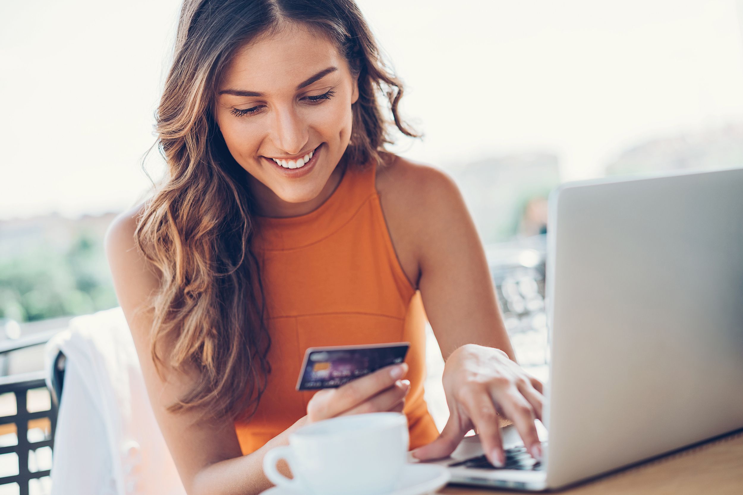 woman buying with credit card online with laptop