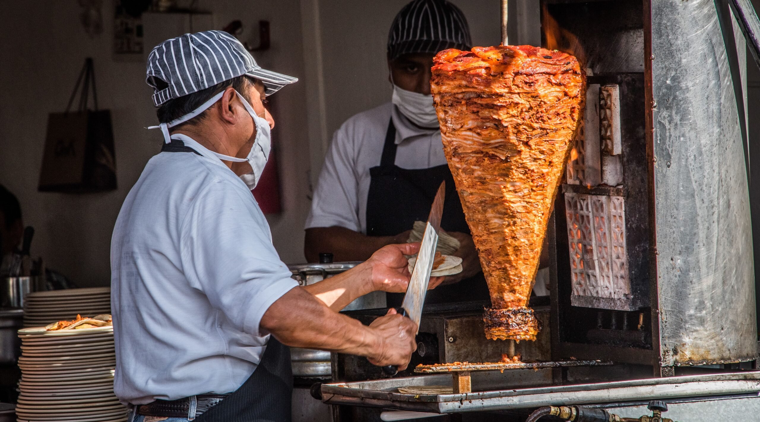 al pastor on the trompo being made into street tacos