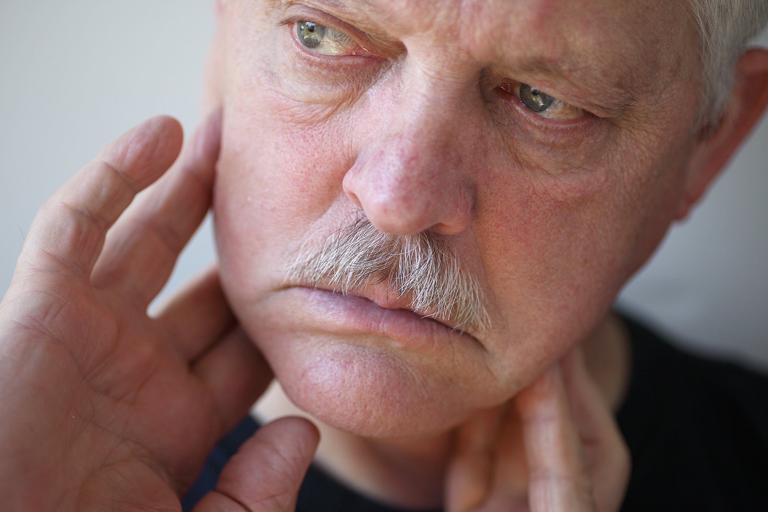 man with fingers on painful jaw