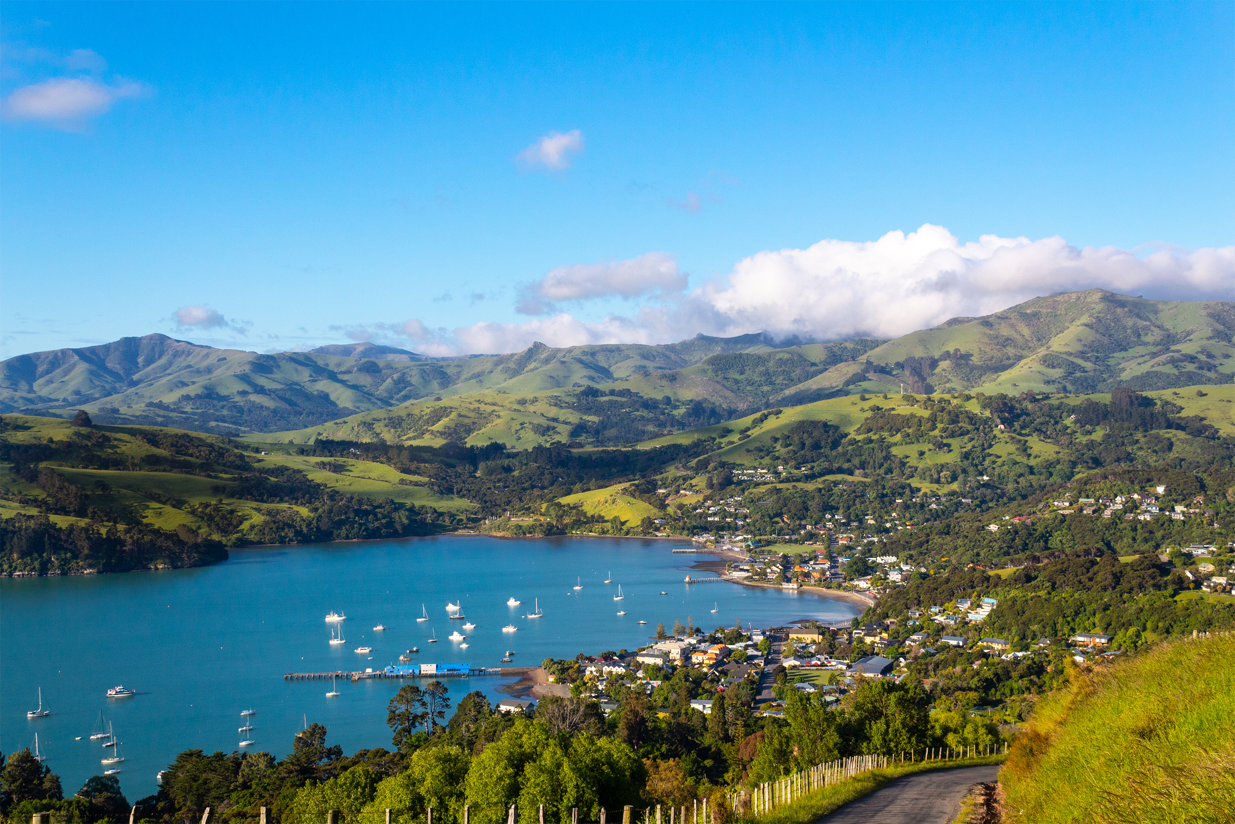 Aerial of Akaroa, Banks Peninsula, South Island, New Zealand, scenic view before sunset, boats in the ocean
