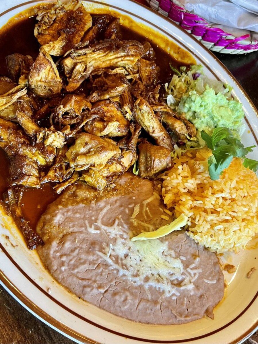 Carnitas a la Coca-Cola with sides on a brown-rimmed plate, Lindo Michoacan, Las Vegas, on a wooden table at the restaurant