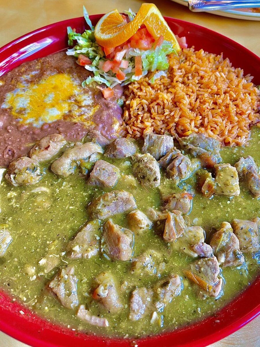 Chilli Verde with sides on a red ceramic plate, Plaza Garibaldi Mexican Restaurant, Seattle, on a table at the restaurant