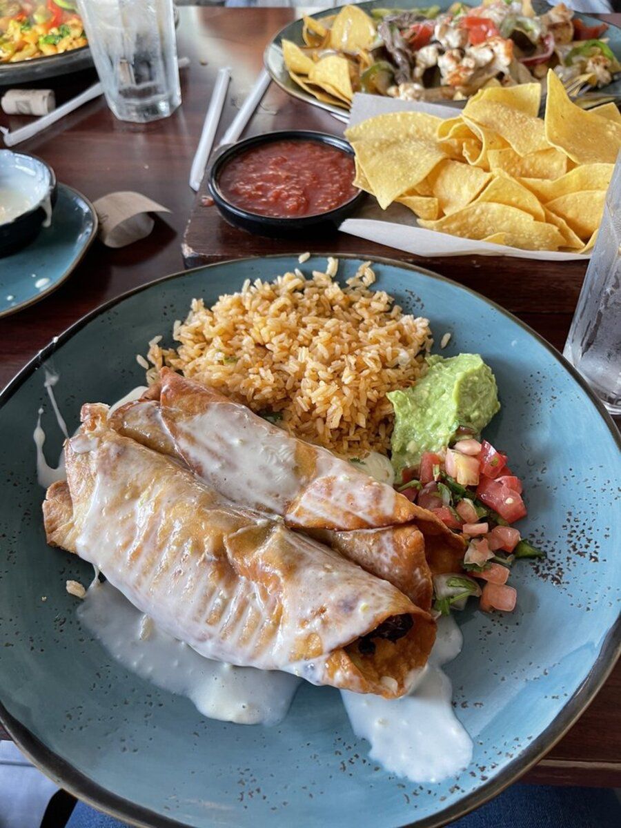 Chimichanga Plate on a brown-rimmed blue plate, Las Palmas Mexican Restaurante, Nashville, several food dishes on a table at the restaurant in the background