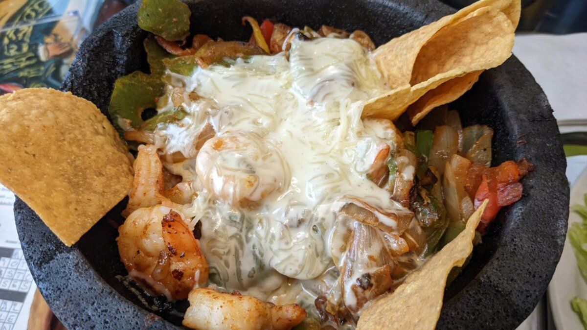 Closeup of Molcajete con Camarones, El Camino Real Mexican Bar & Grill, Winchester, Kentucky, on a quirky table at the restaurant blurred