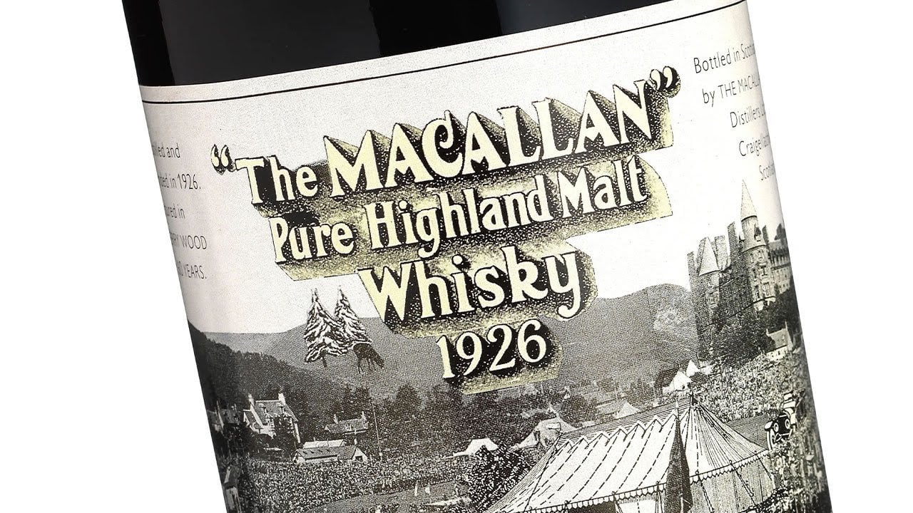 Close-up of a vintage bottle label reading "The Macallan Pure Highland Malt Whisky 1926," an icon among expensive collectibles, featuring an illustration of a distillery and its picturesque landscape.
