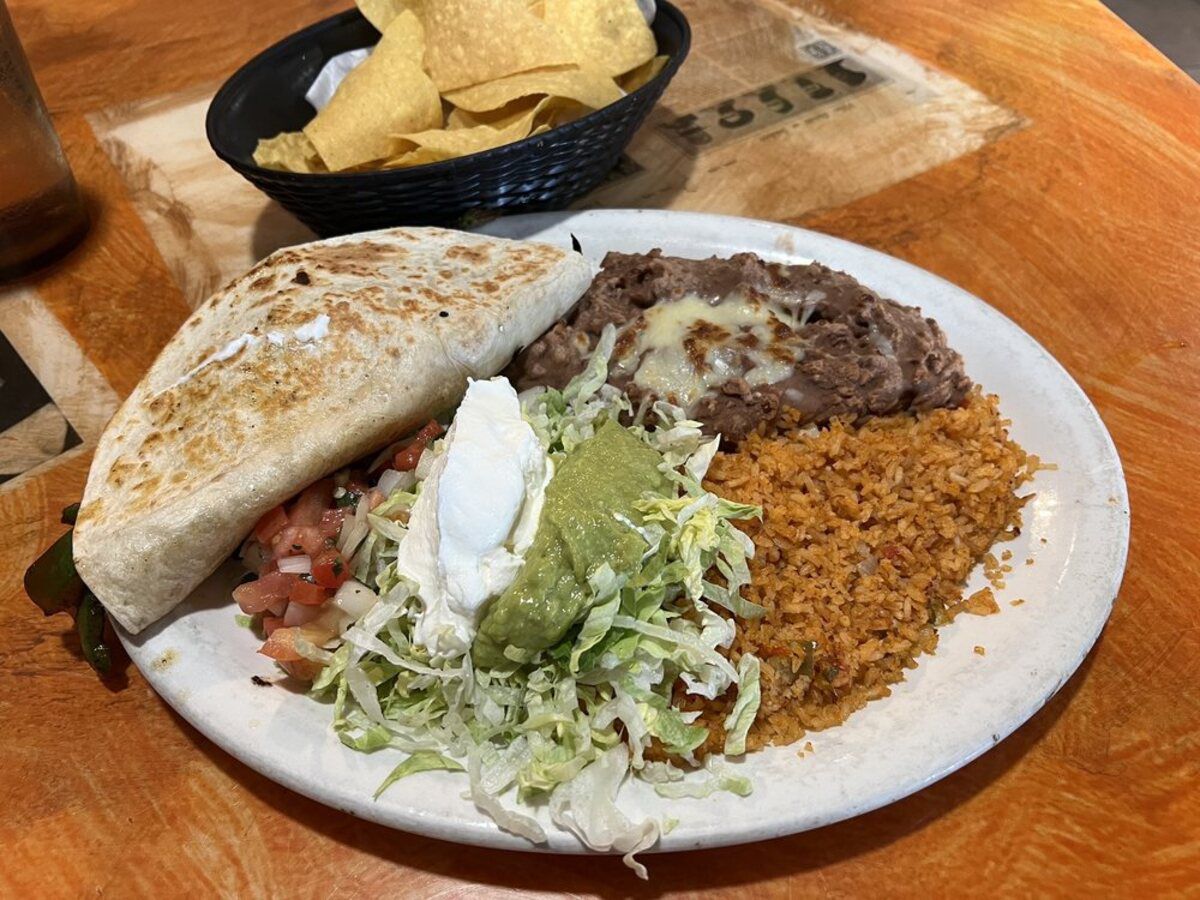 Mexican Dish on a white plate, Monterrey Mexican Restaurant, Knoxville, Tennessee, with a side of chips and a glass of water on a a wooden table at the restaurant
