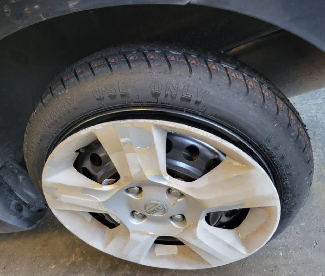 An image of someone who failed miserably to set up their spare tire in a safe manner.