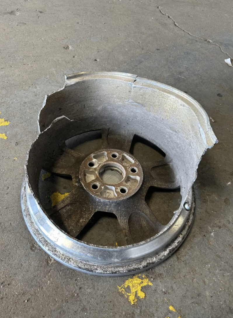 An image of the aftermath of a car that drove over a horrible pot hole.