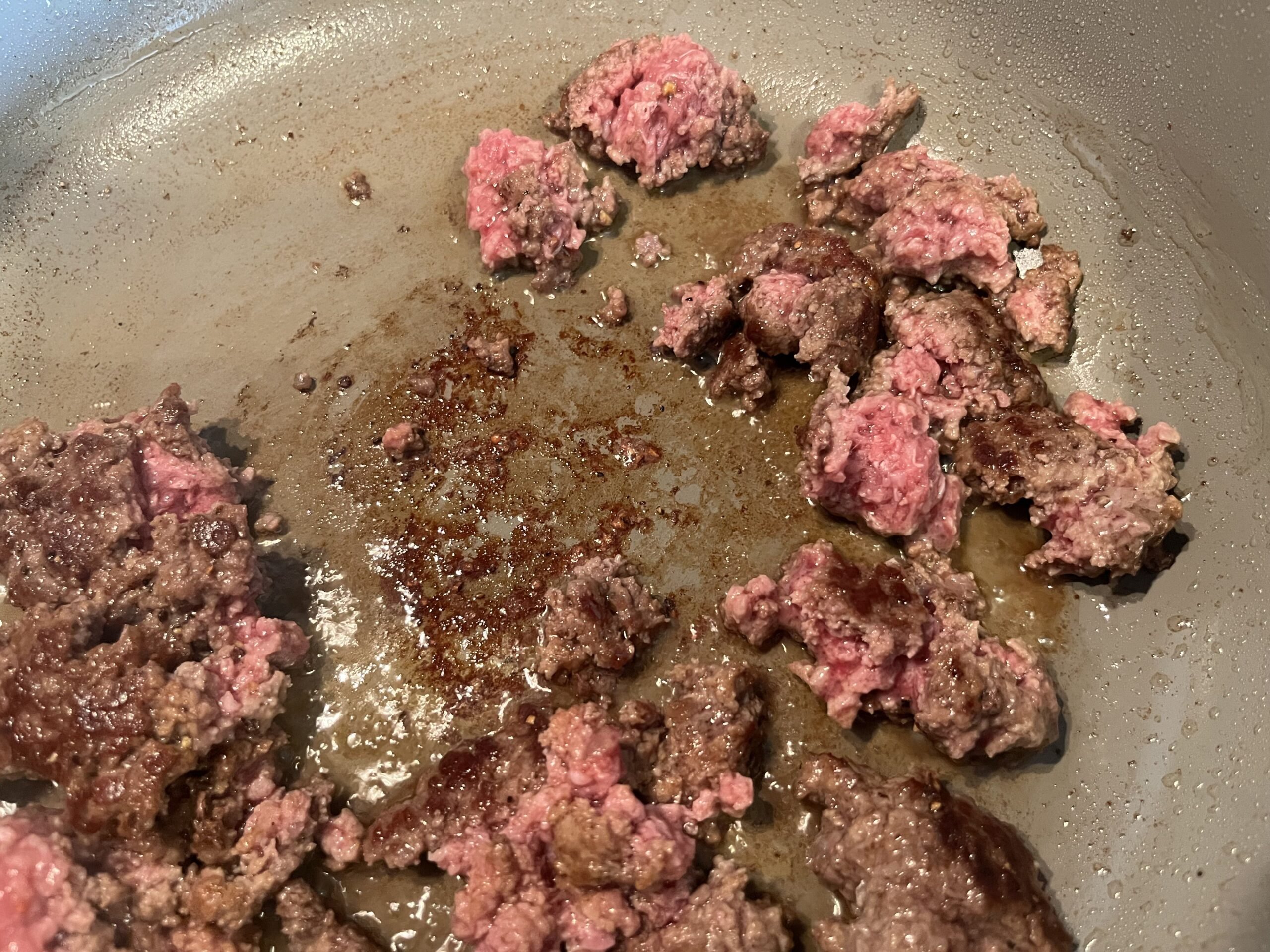 ground beef cooking in a pan