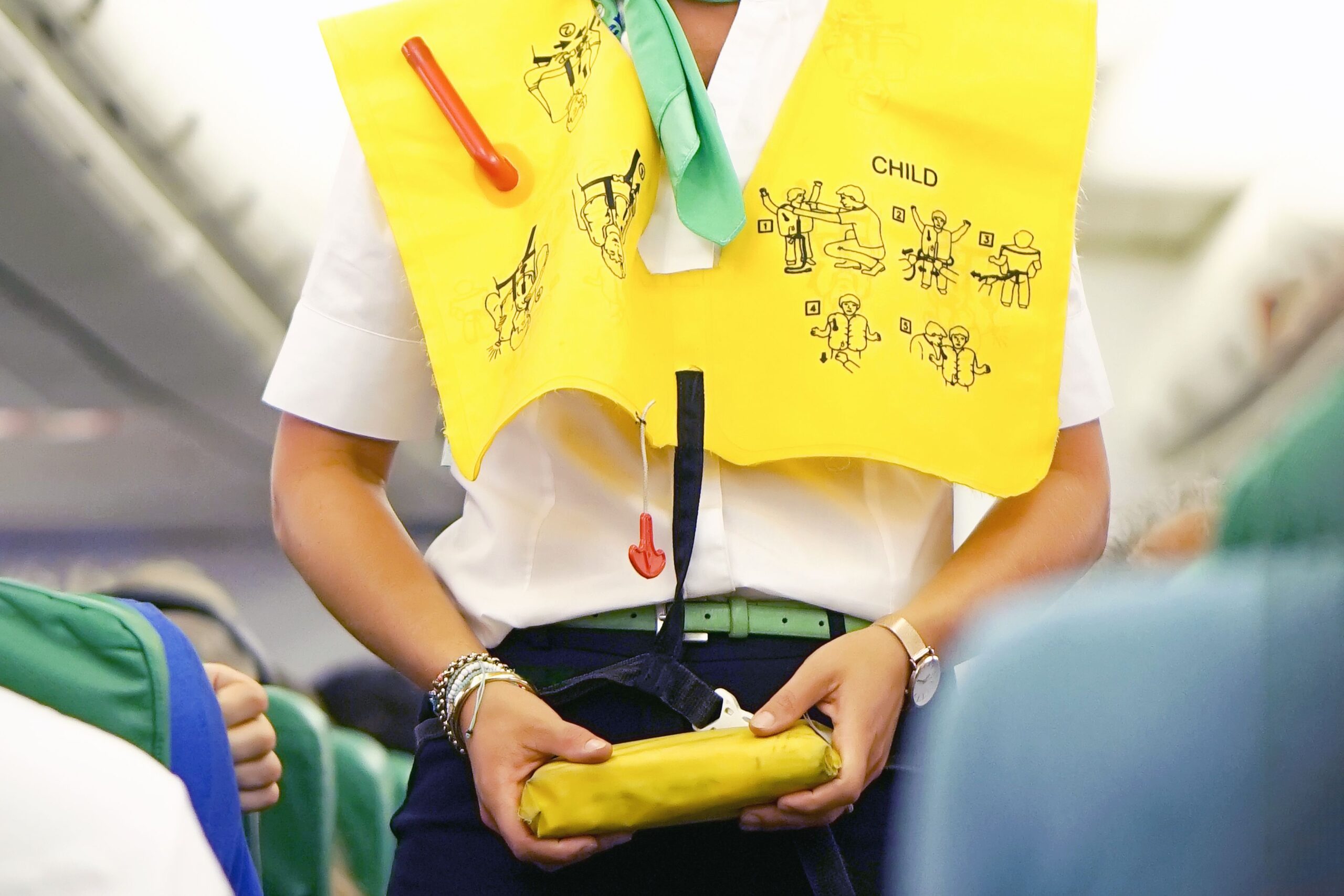 Stewardess in the cabin passenger airplane instructs passengers on safety measures in the event of an emergency
