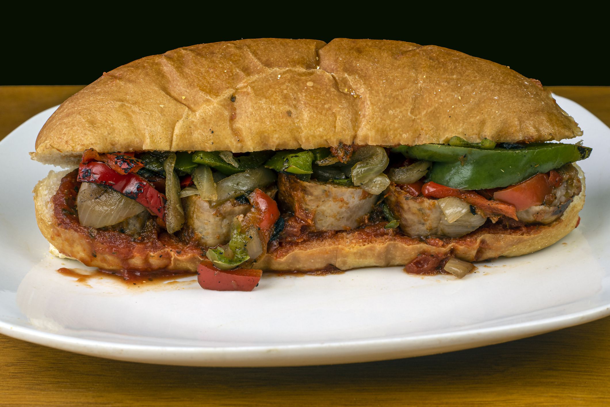 suasages onions and perrs on a hoagie with sauce