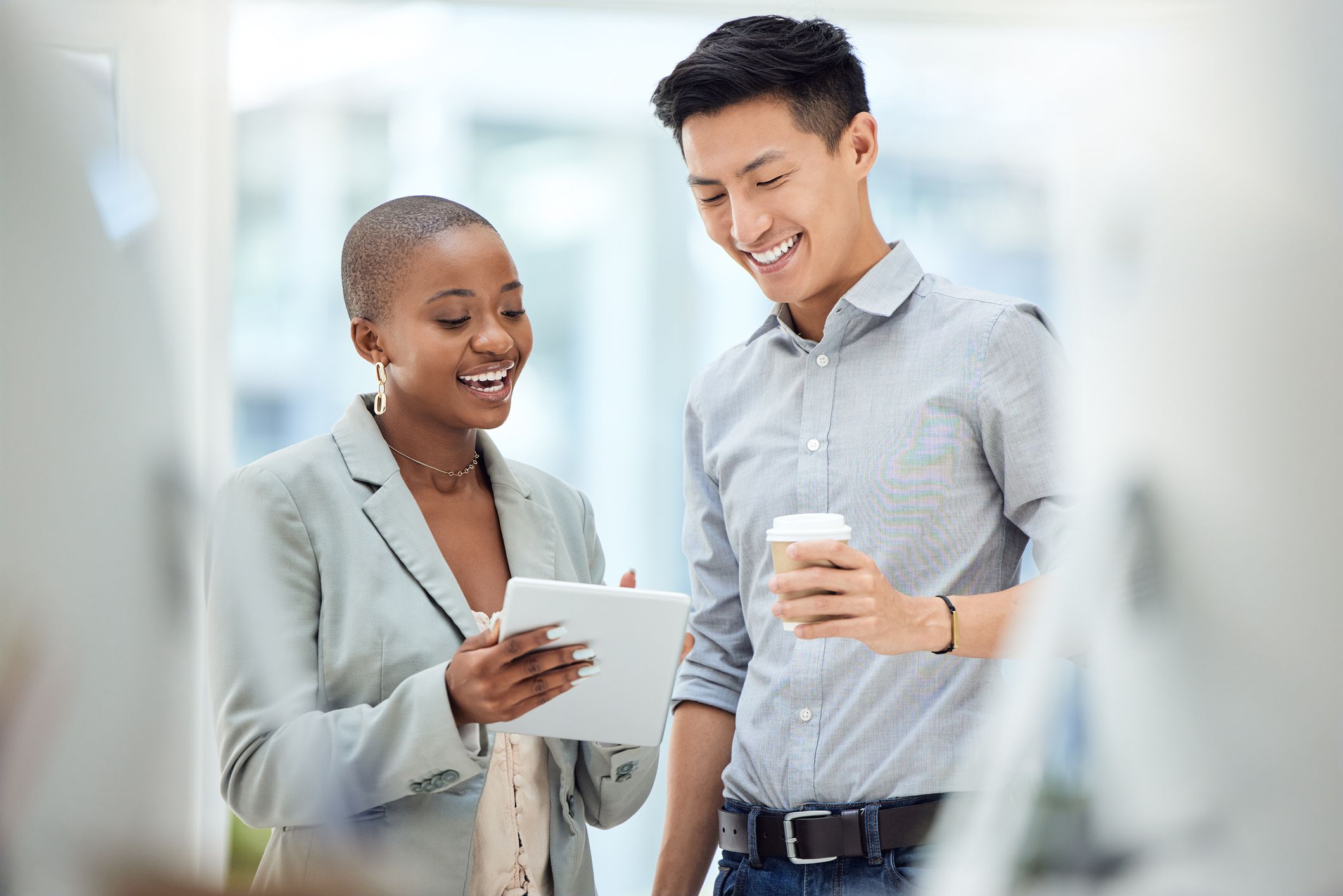 Tablet, smile and employees talking about business on the internet, online partnership and reading an email together at work. Marketing workers with idea for creative collaboration on technology