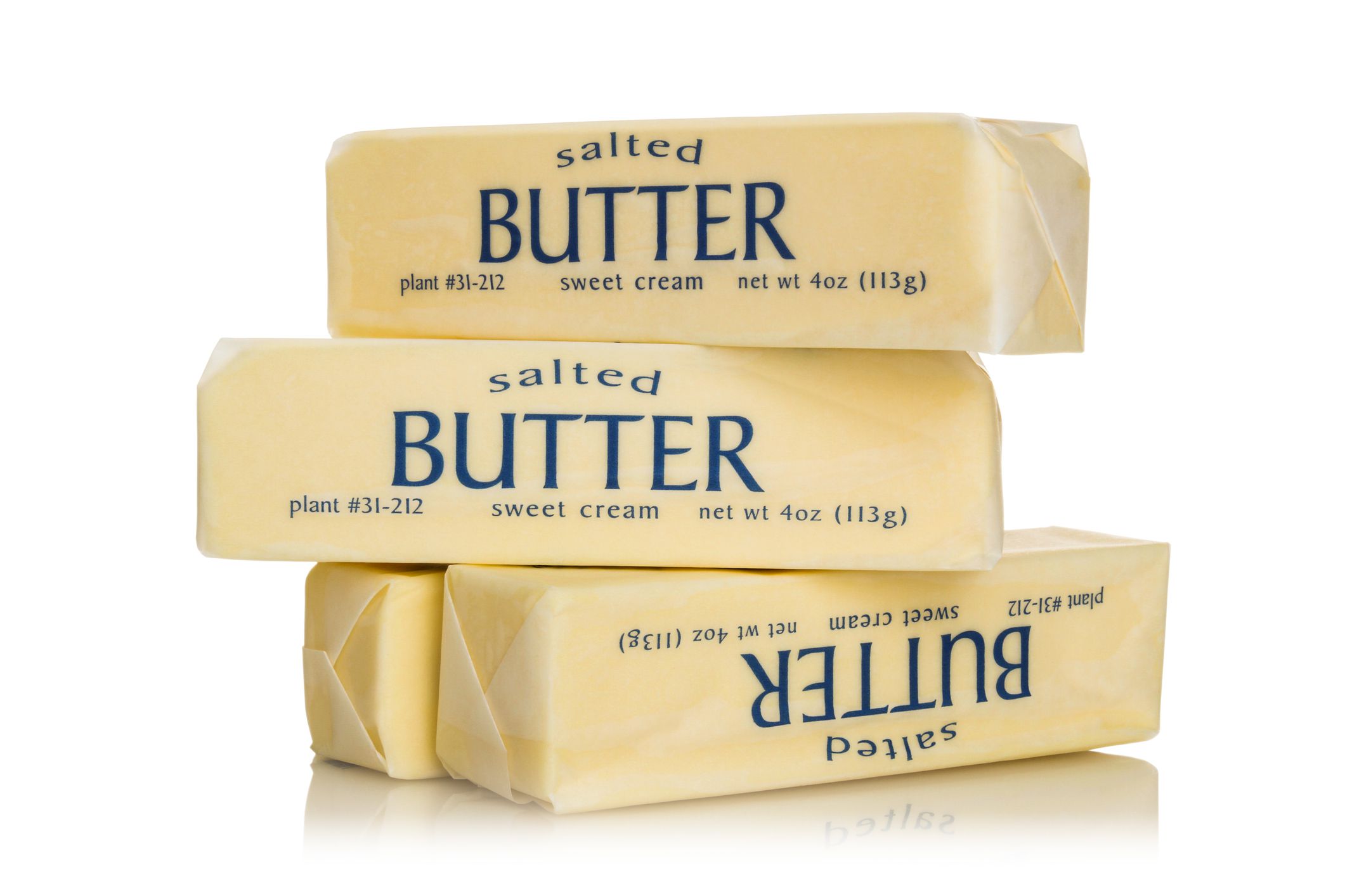 Four sticks of salted butter isolated on white.