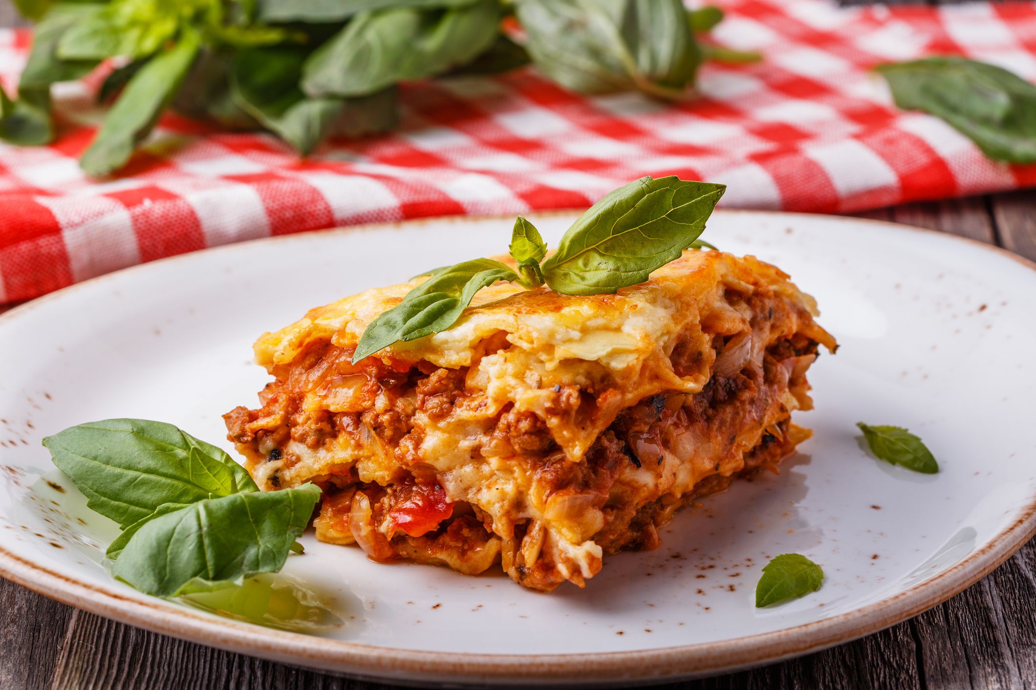 Traditional lasagna made with minced beef bolognese sauce and bechamel sauce topped with basil leaves.