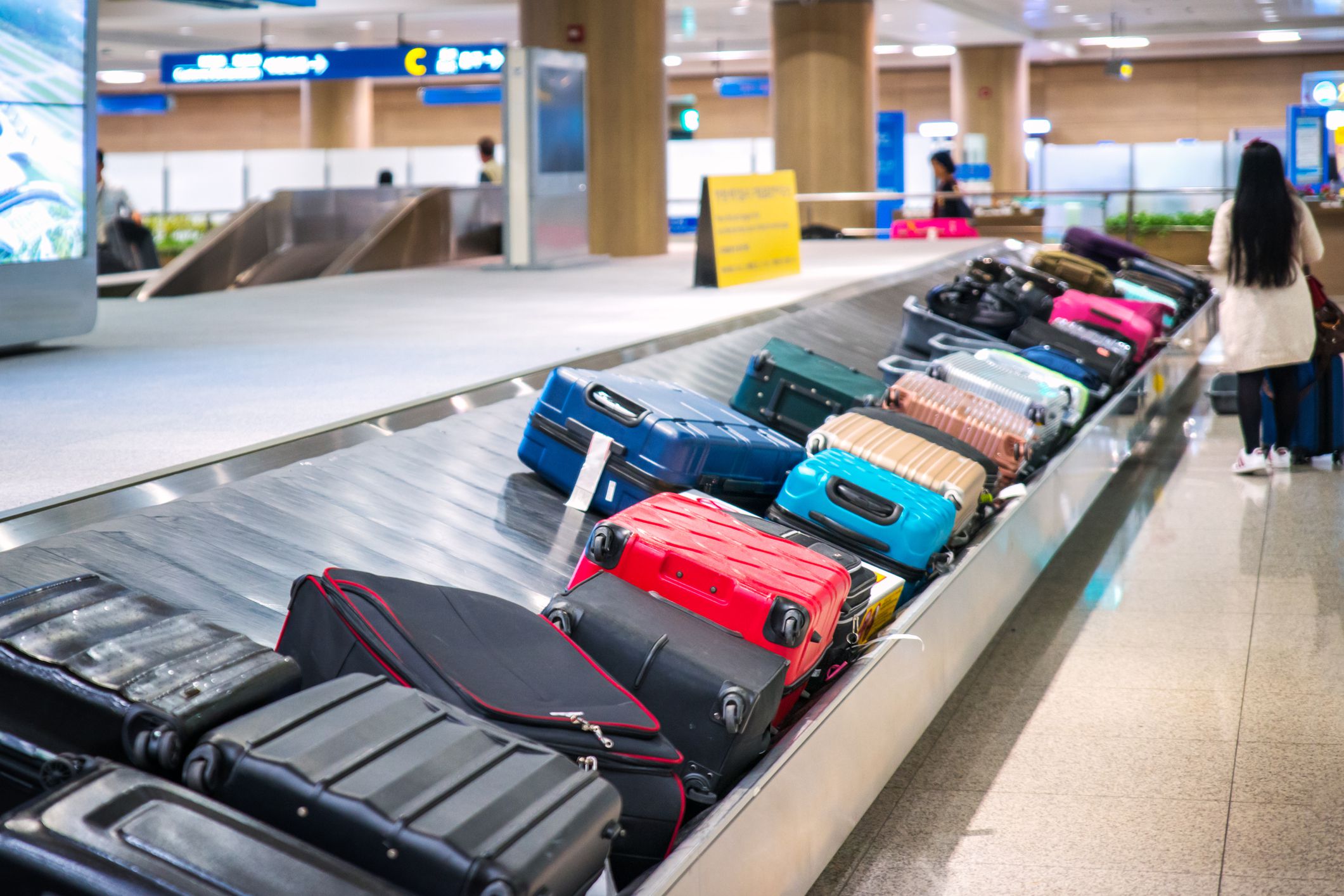 Traveler waiting for a travel bag on the belt in airport after arrival to airport destination flight