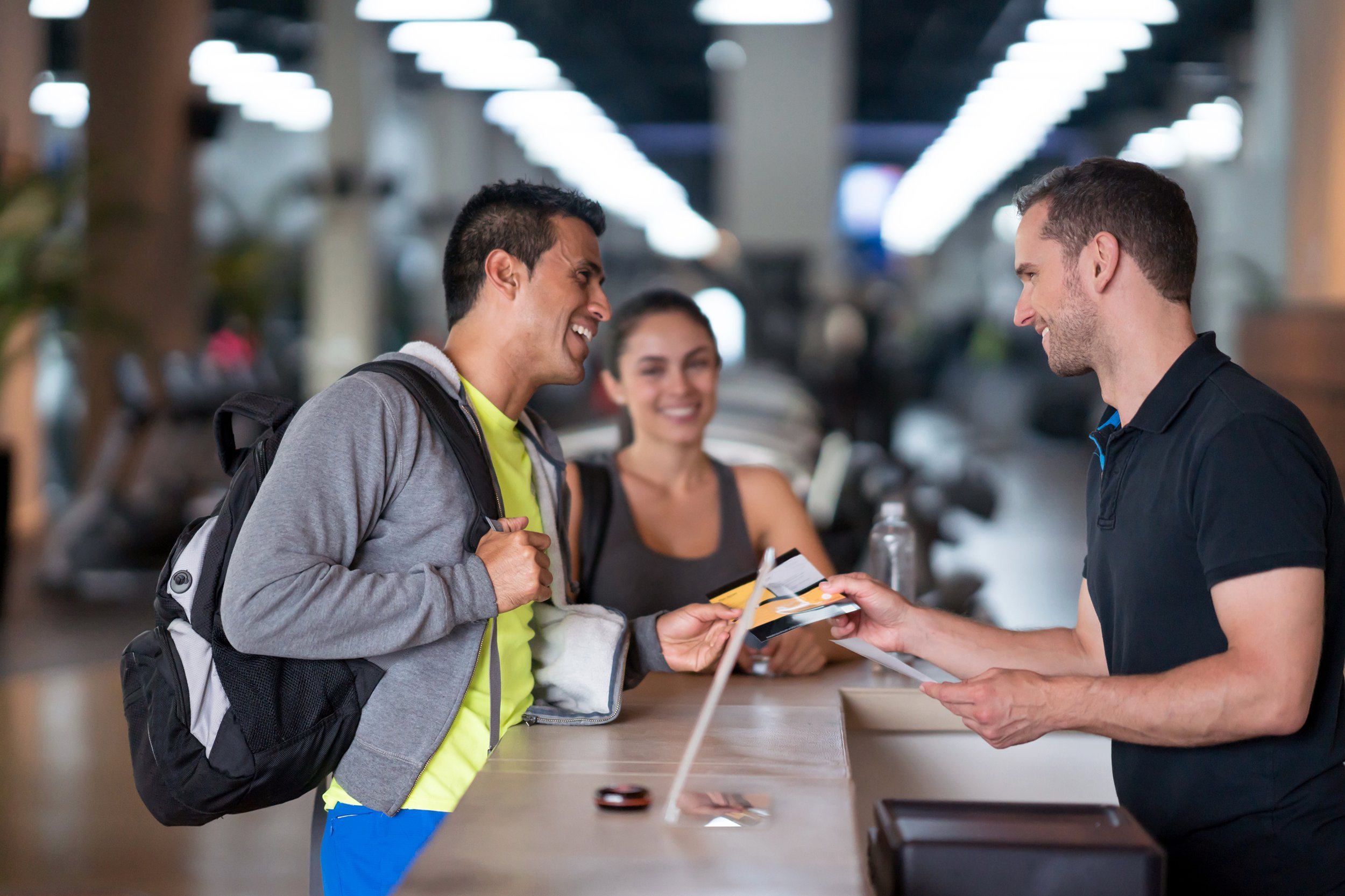 Two people speaking with a fitness club employee