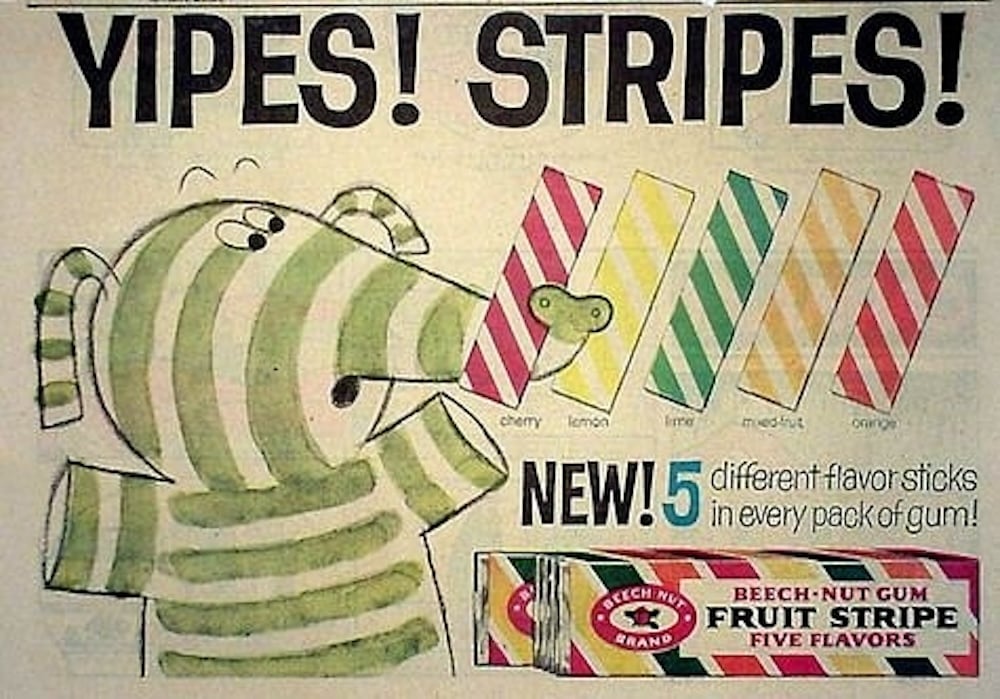 A colorful vintage ad features a striped cartoon zebra pointing to five striped gum sticks labeled cherry, lemon, lime, mixed fruit, and orange. Text reads: "Yipes! Stripes! NEW! 5 different flavor sticks in every pack of gum!