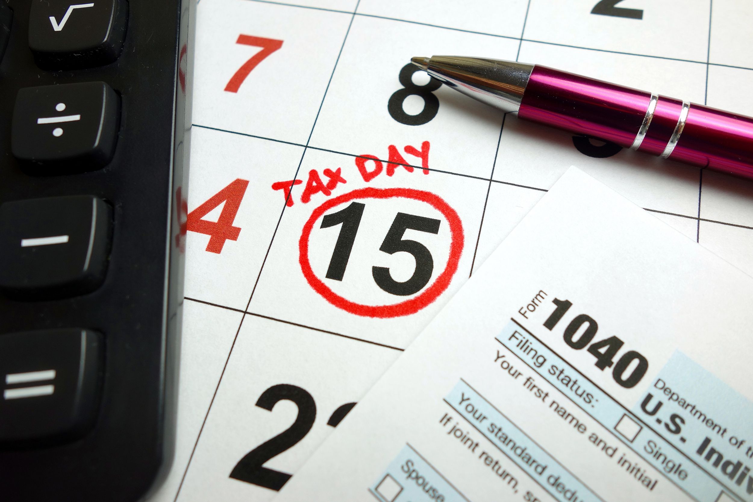 April 15th on calendar with pen, tax form and calculator