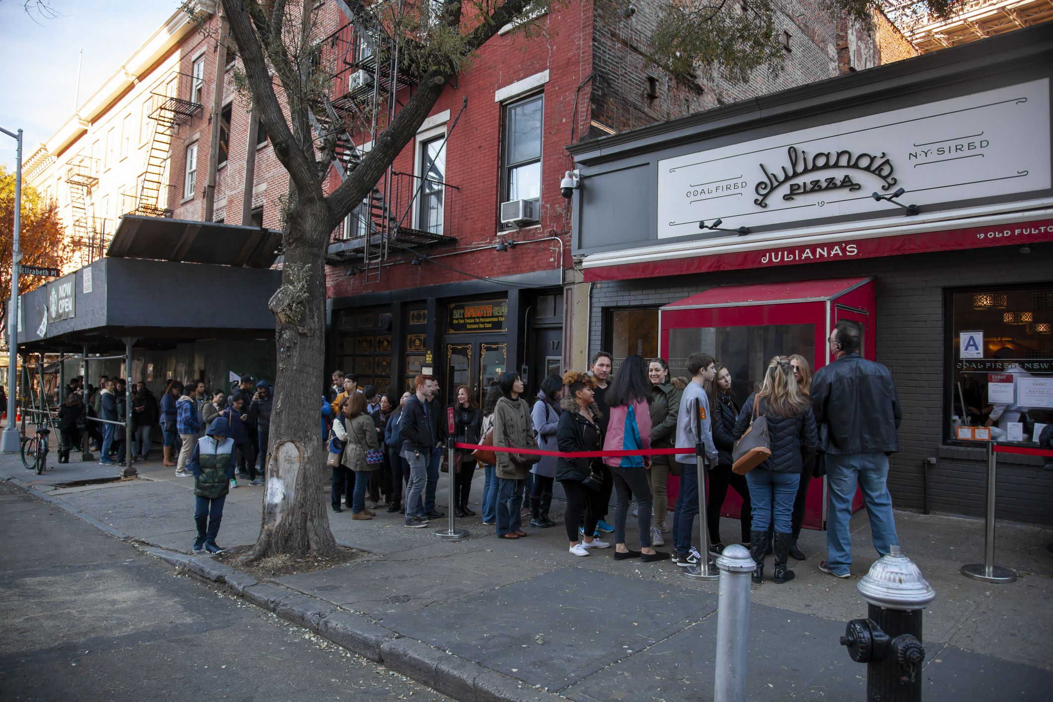 New York, USA 11/25/2017: Long lines form in front of highly popular Juliana's Pizza which is a long standing favorite for pizza lovers visiting Brooklyn.
