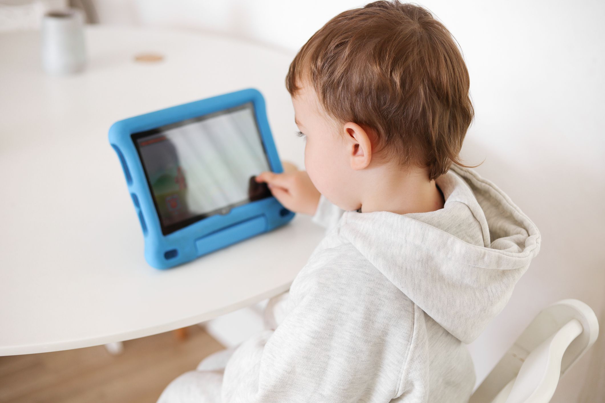 Happy little boy playing game on digital tablet at home. Portrait of a child at home watching cartoon on the tablet. Modern kid and education technology