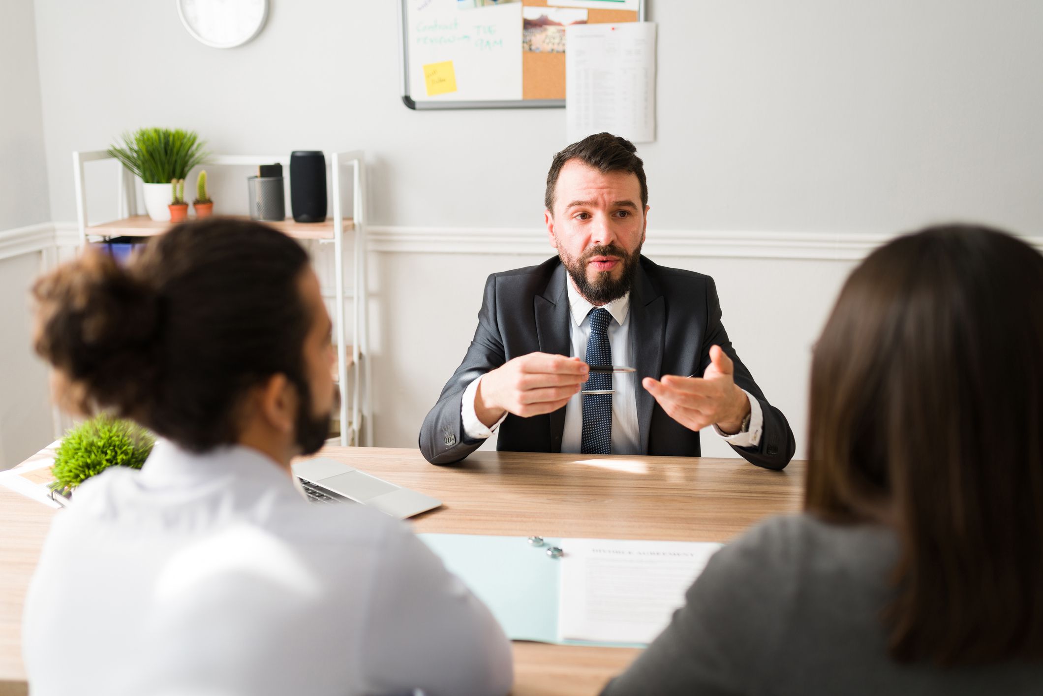 Hispanic divorce attorney explaining the legal procedure to a couple signing the papers