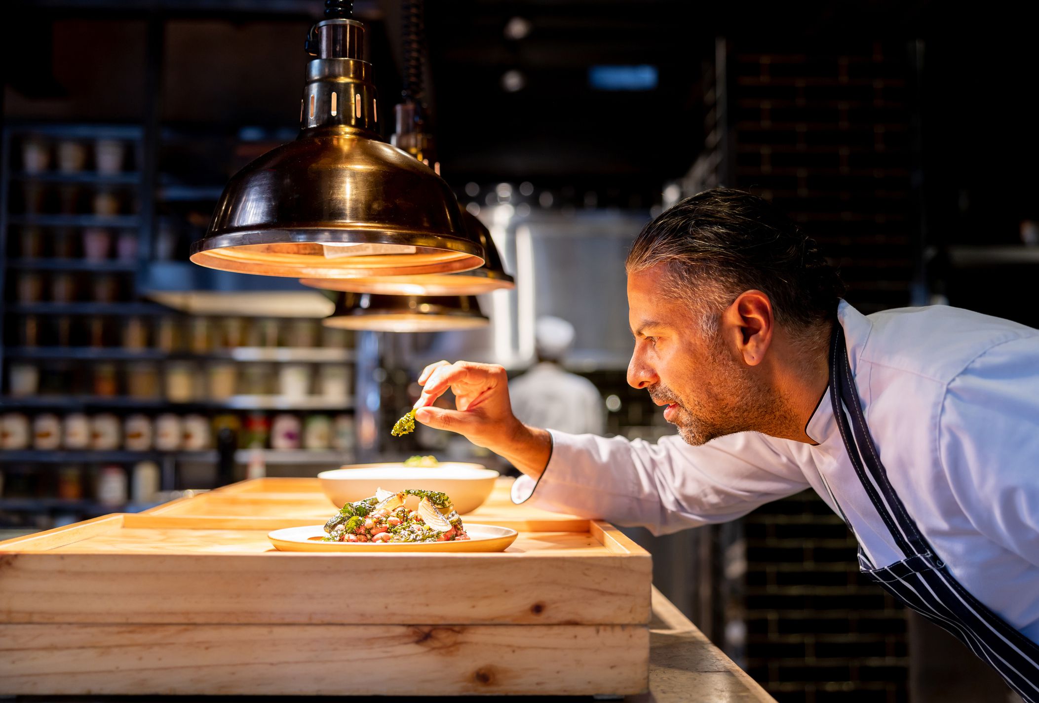 Chef decorating a plate while working in the kitchen at a restaurant - preparing food concepts