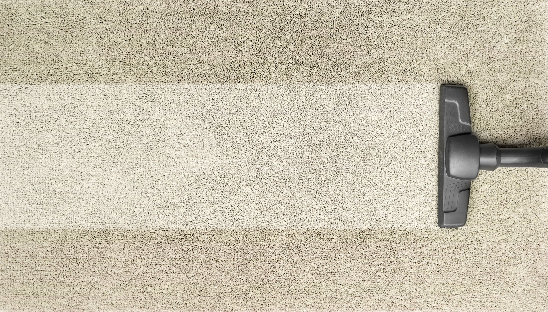 House cleaning concept: Cleaning the brown carpet with the vacuum cleaner