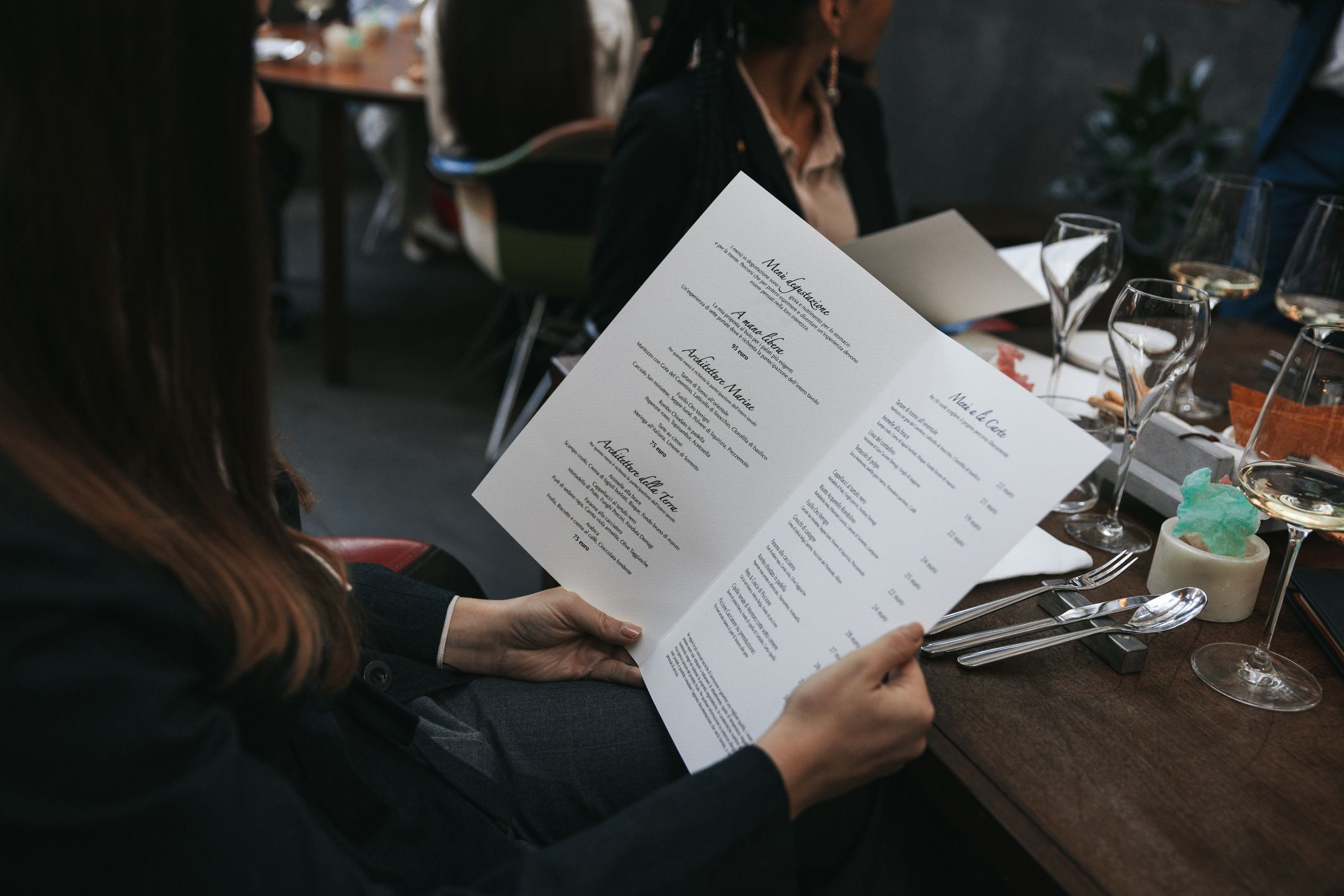 Fine dining restaurant, young woman reading a paper menu