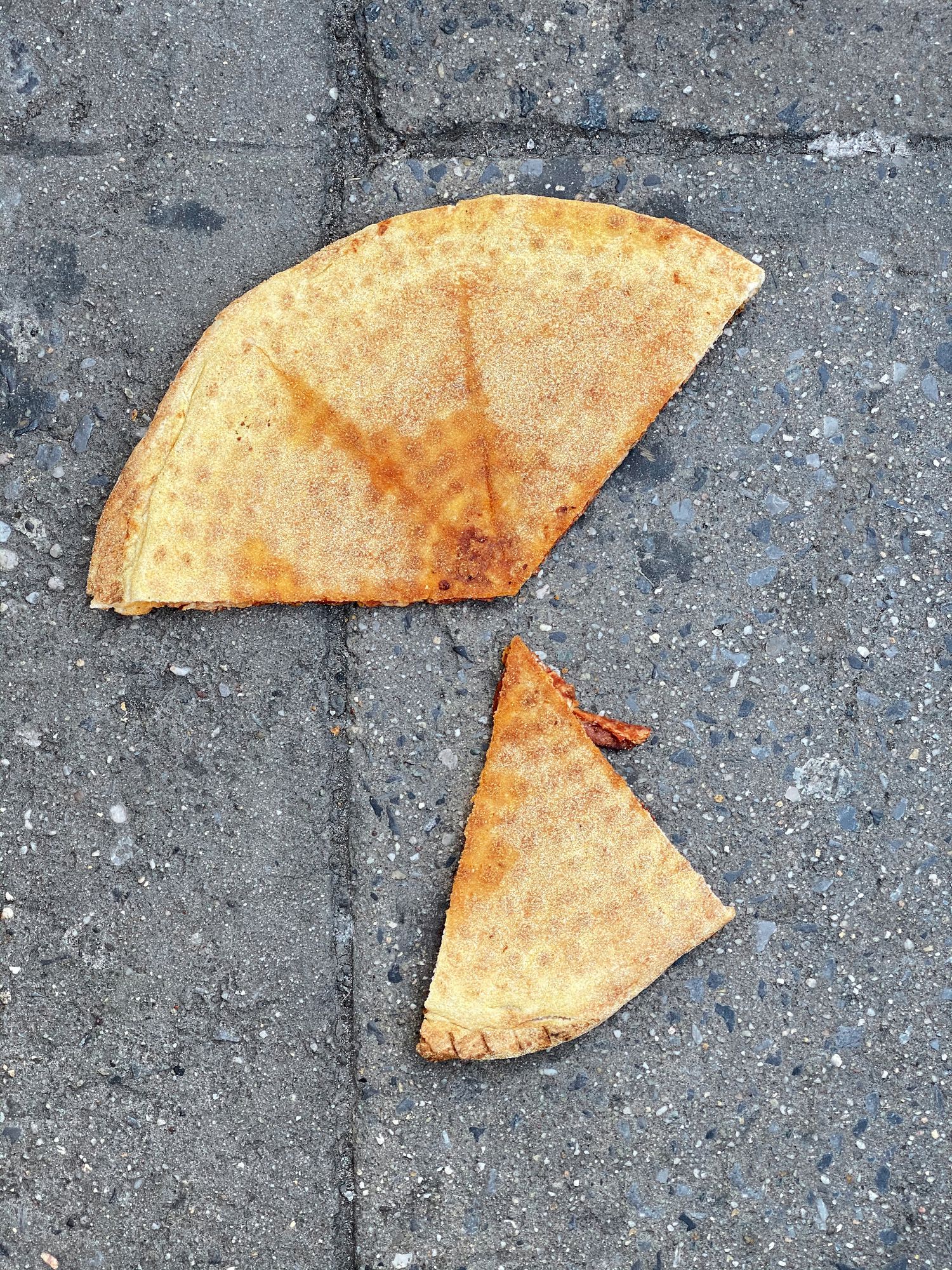 Pizza thrown on a sidewalk