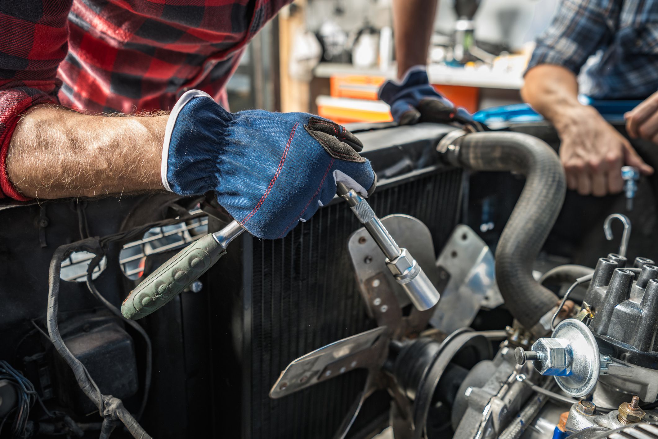 Professional Caucasian Mechanic Taking Care of a Classic Car Engine. American Muscle Cars Theme.