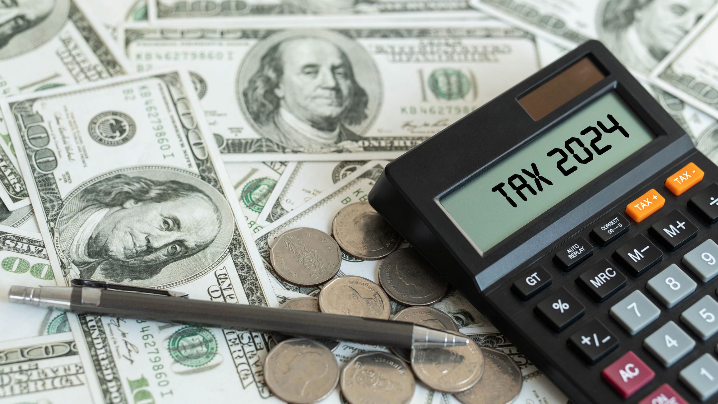 Tax 2024. Word Tax 2024 on calculator. Business and tax concept. Calculator, currency, dollar bills close up. Income Statement. paying the tax rate. Taxation, investment, taxes burden.