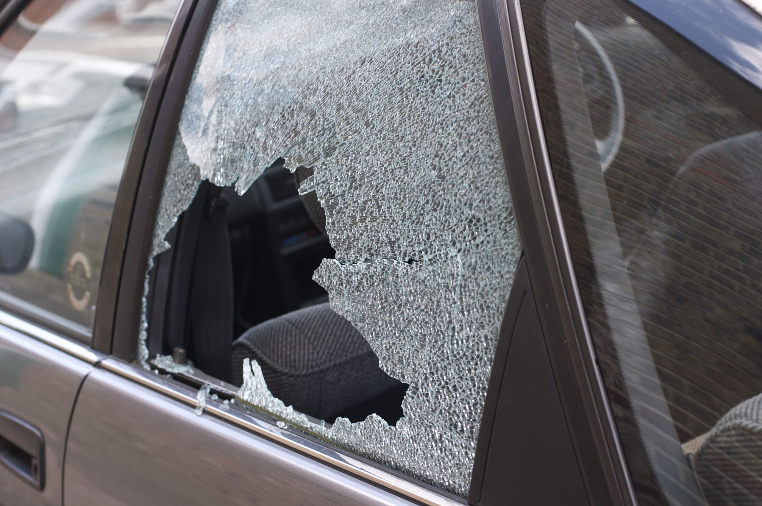 Cracked and crazed glass reveals the workings of a thief in the night, during the morning after. One more car crime in London.