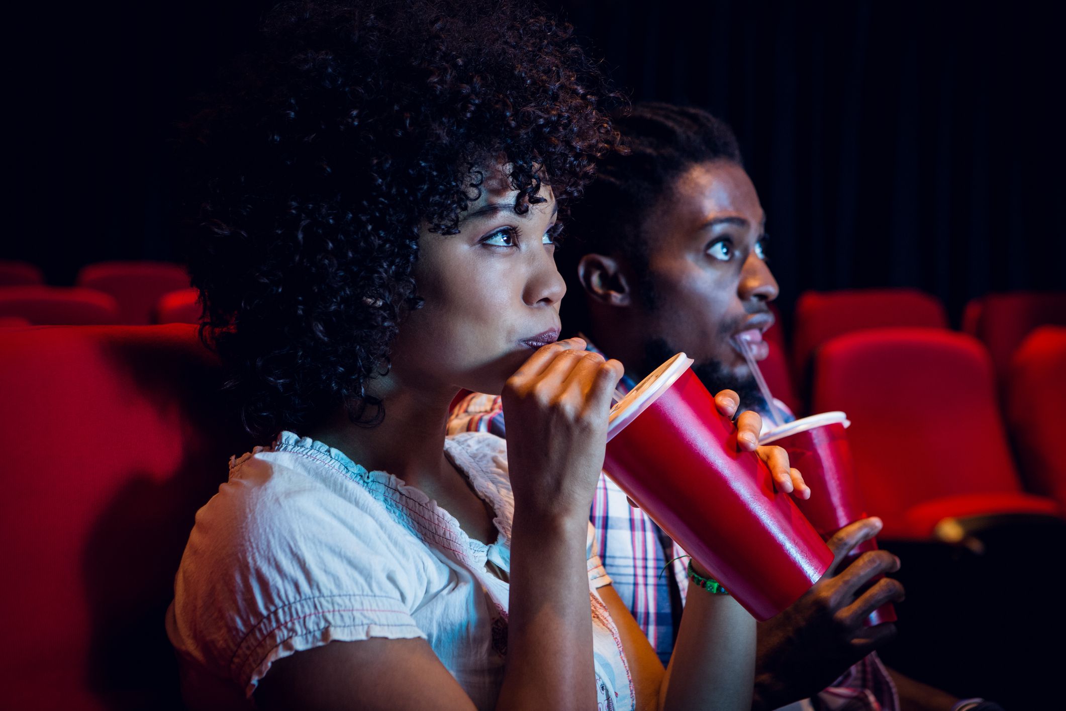 Young couple watching a film at the cinema