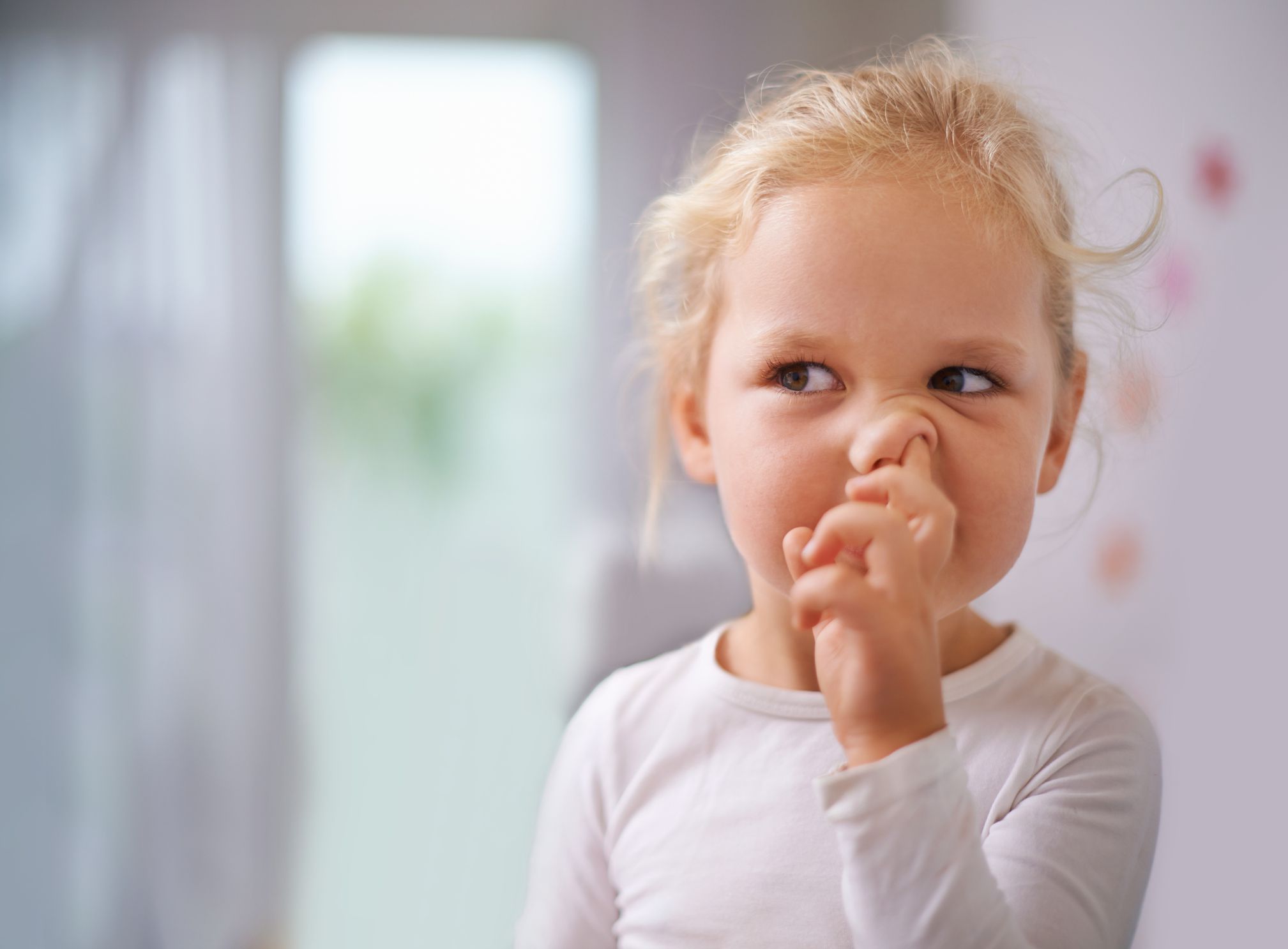 A little girl picking her nose