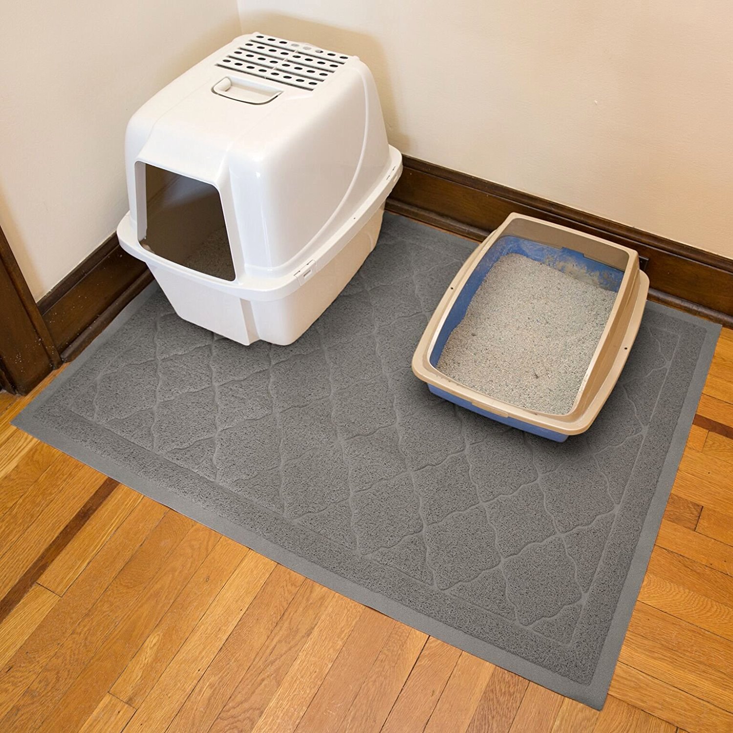 Litter boxes on top of a grey bath mat