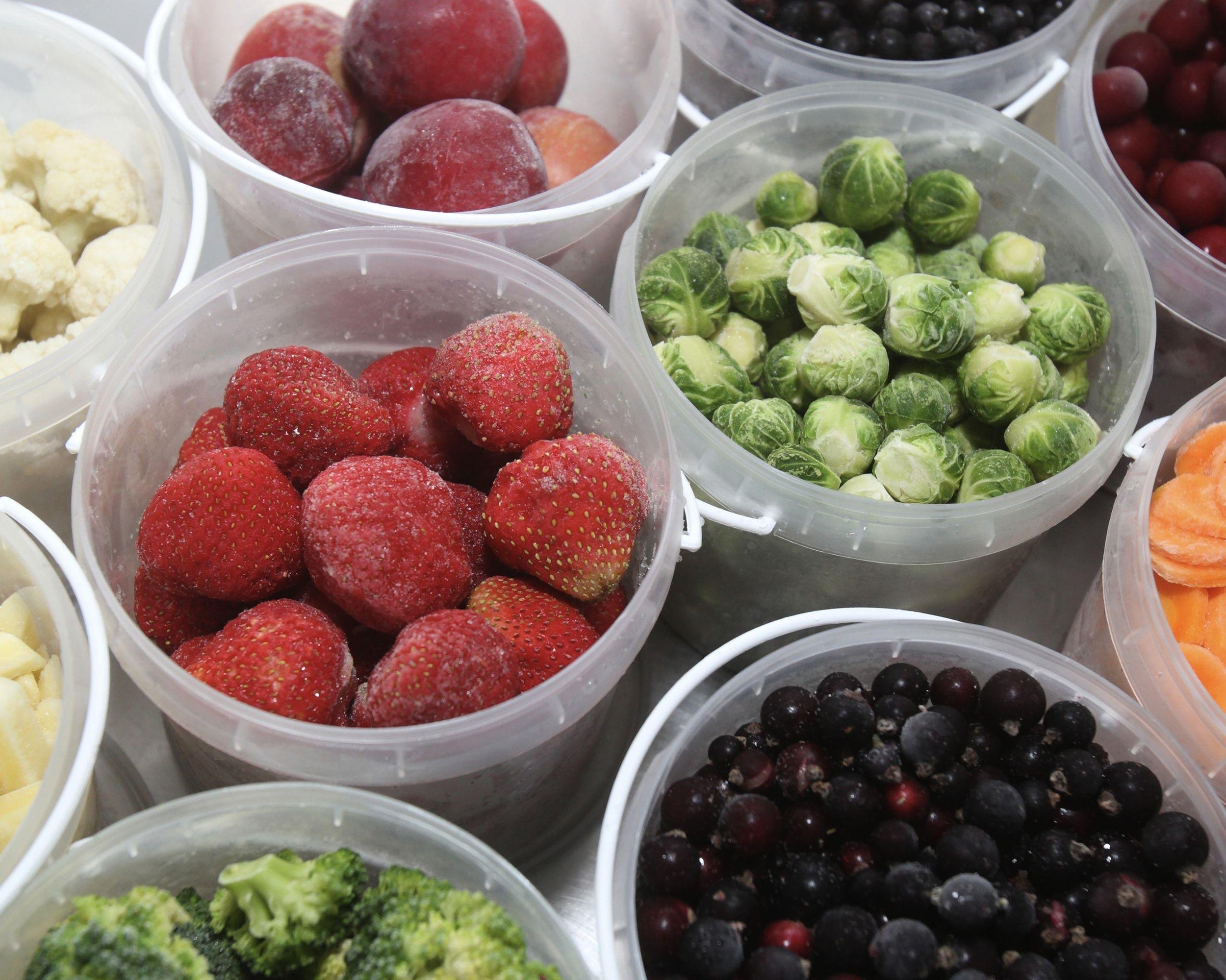assorted frozen fruits and vegetables in plastic containers