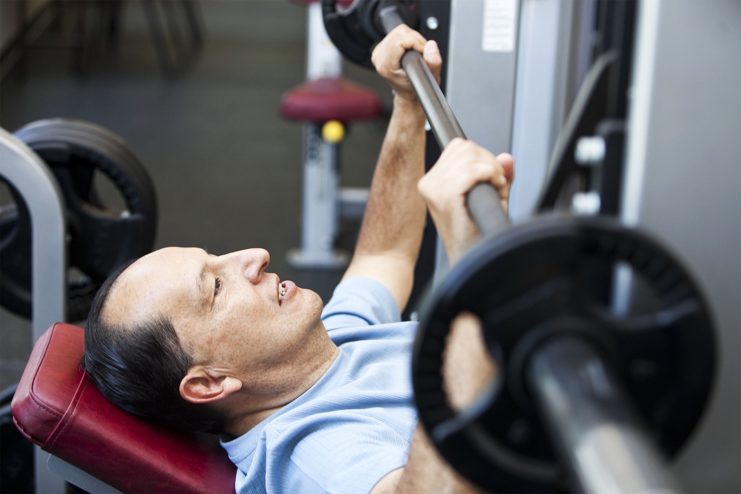 Older man using a bench press