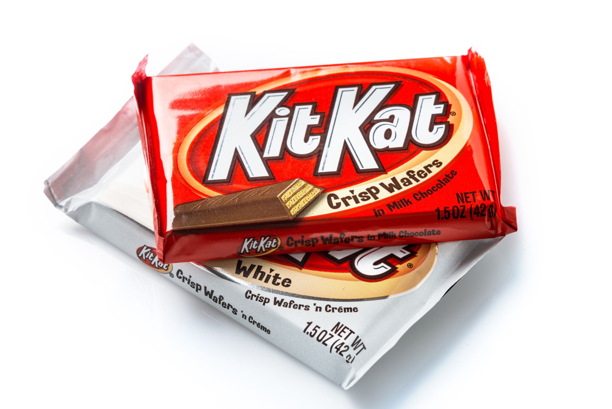 Two packages of Kit Kat crisp waffers, one regular milk chocolate, the other white milk chocolate flavor
