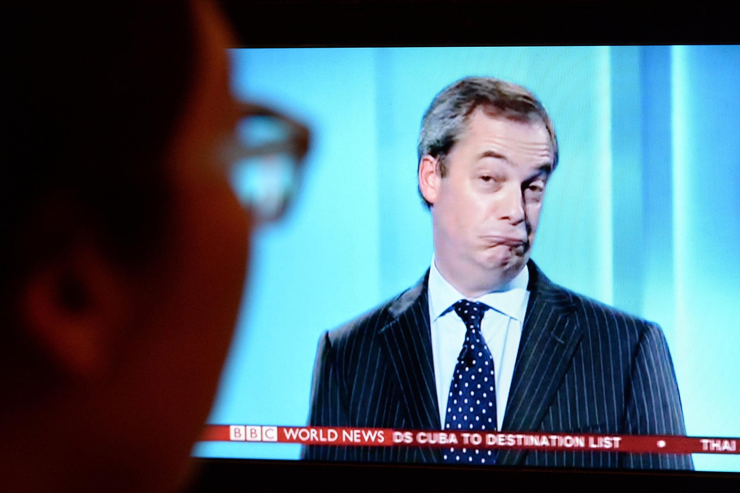 Viewer watches UKIP leader Nigel Farage on a TV screen during an election debate on Apr 4, 2015 in London, UK