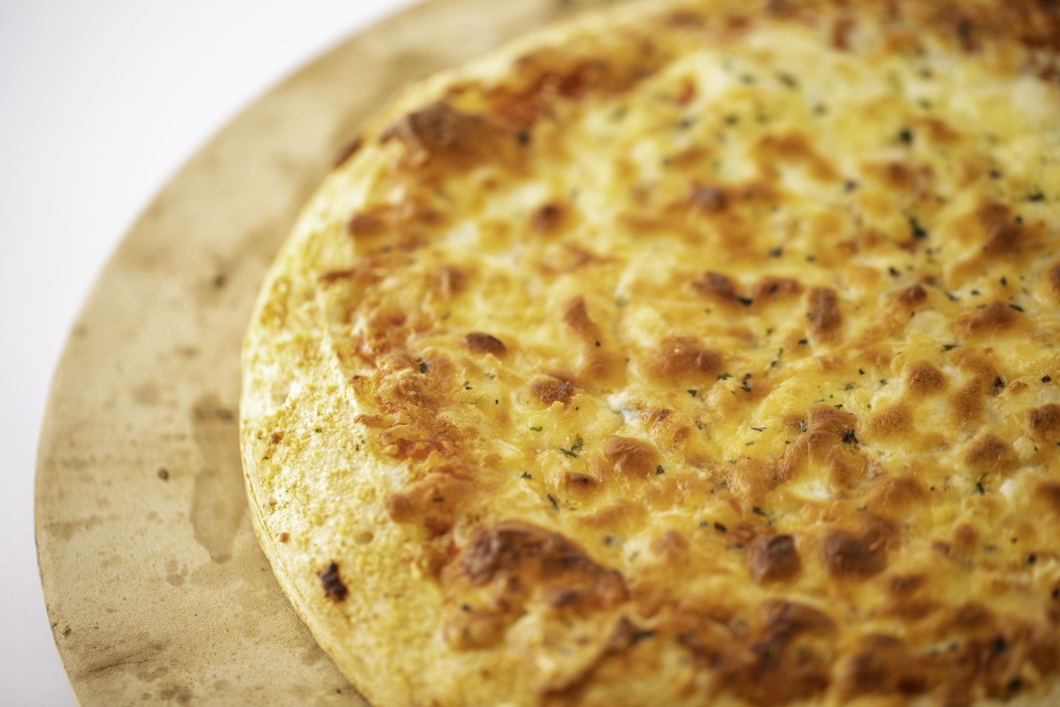 Cheese pizza on a pizza stone on a white background