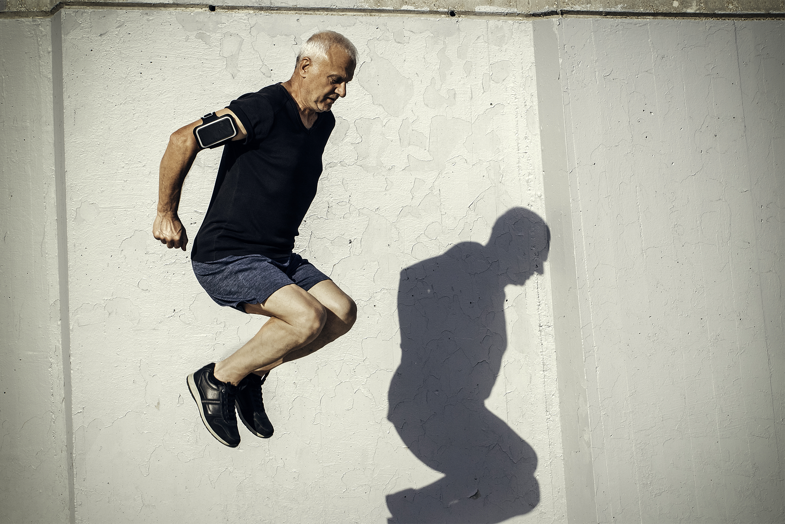 senior man jumping outside while exercising