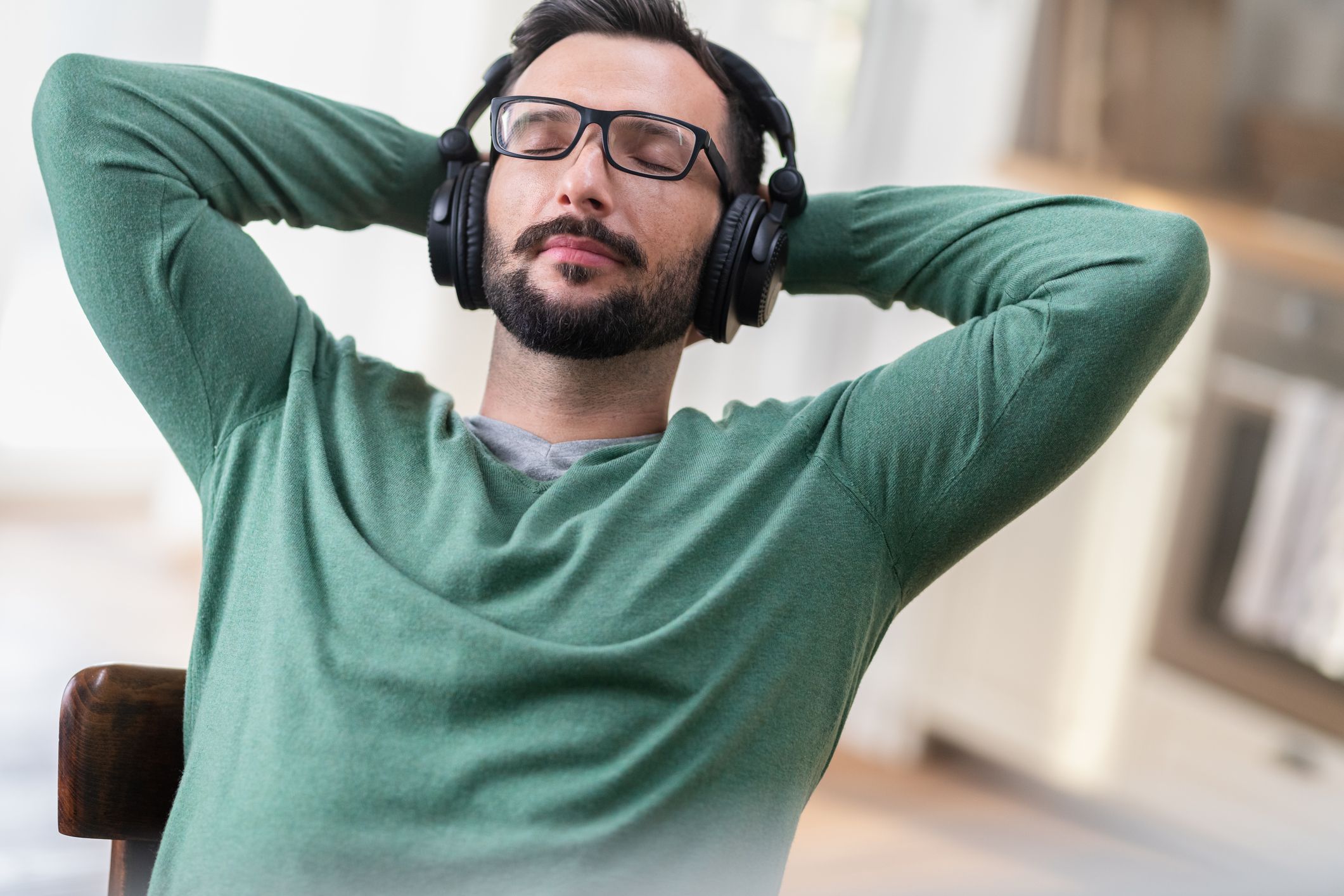 Cropped shot of a handsome young man listening to music on his tablet while relaxing on a sofa at home.