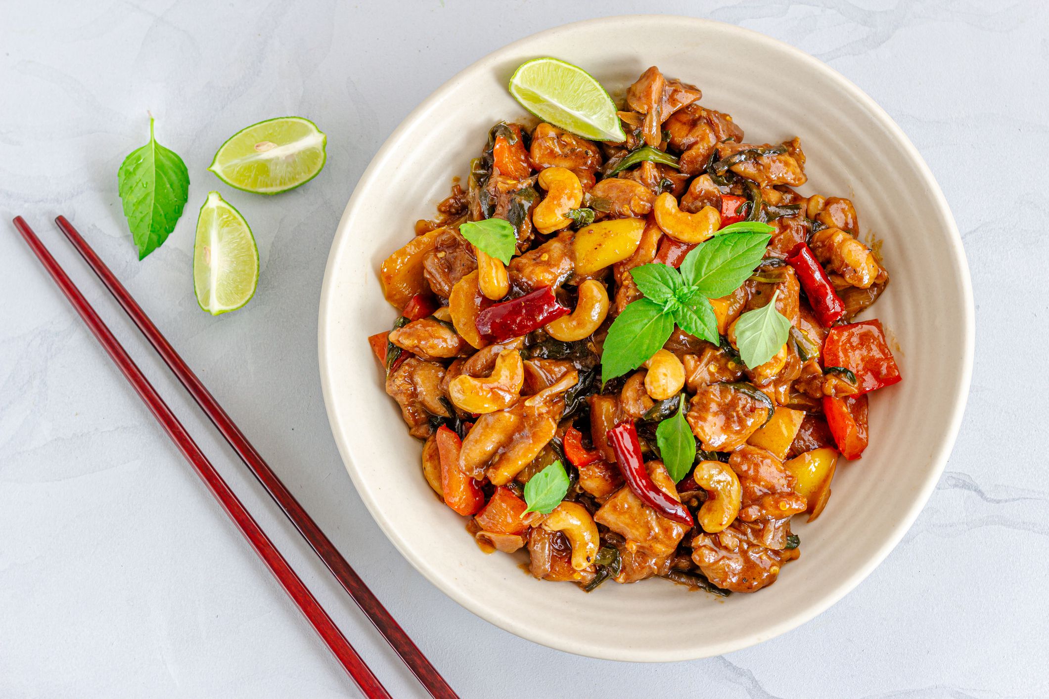 Thai Stir-Fried Chickenwith Chopsticks Directly Above Photo on White Background