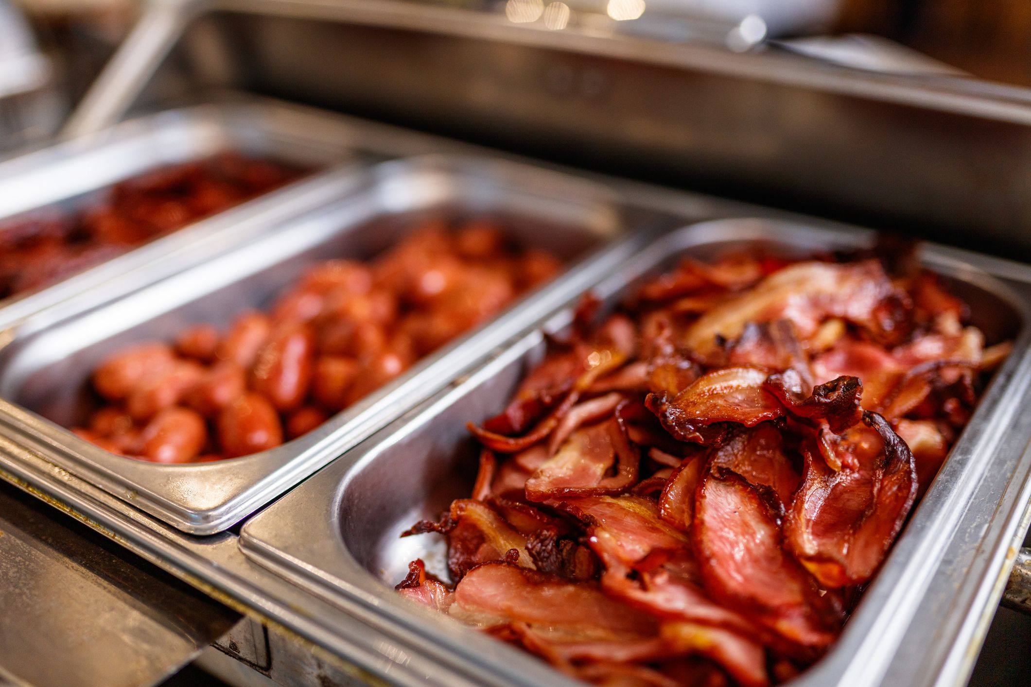 Various meat in steel containers for serving in a buffet at the restaurant