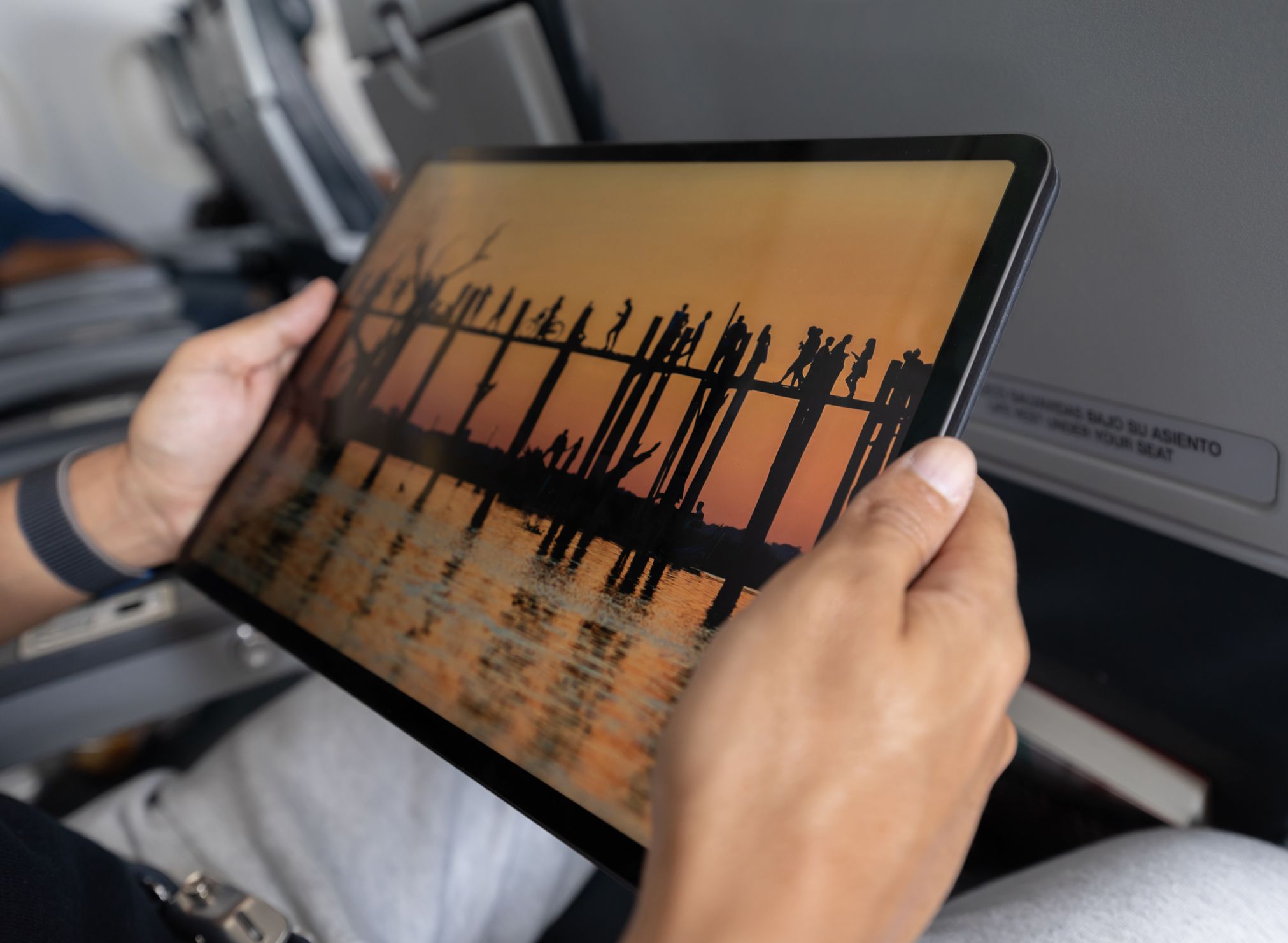 Close-up on a traveler watching a movie in an airplane using his tablet - onboard entertainment concepts **PHOTO BELONGS TO US**
